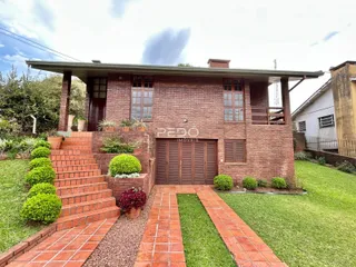 Fachada de casa de tijolos vermelhos com jardim e caminho de tijolos.