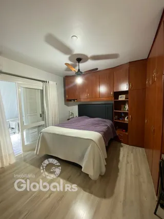 Quarto com cama e armário de madeira no interior da propriedade.