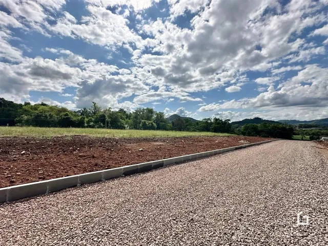 Paisagem de terra arada e uma estrada de cascalho em uma propriedade.