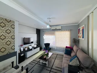 Sala de estar moderna com sofá e televisão em um apartamento no Brasil.