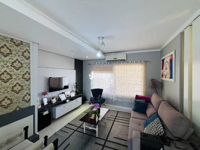 Sala de estar moderna com sofá e televisão em um apartamento no Brasil.