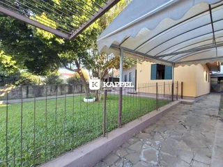 Fachada de uma residência em Lajeado, Brasil, mostrando o jardim e a cerca frontal.