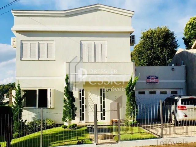 Fachada de uma casa em Lajeado, Brasil, com pintura branca e grade de ferro.