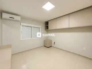 Uma sala de estar clara com armários embutidos e janela.