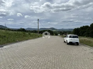 Vista da rua pavimentada em Lajeado, Brasil, com vegetação ao redor.
