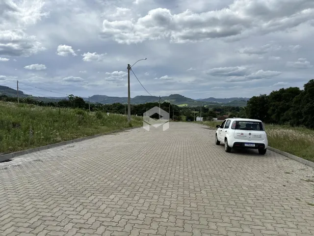 Vista da rua pavimentada em Lajeado, Brasil, com vegetação ao redor.