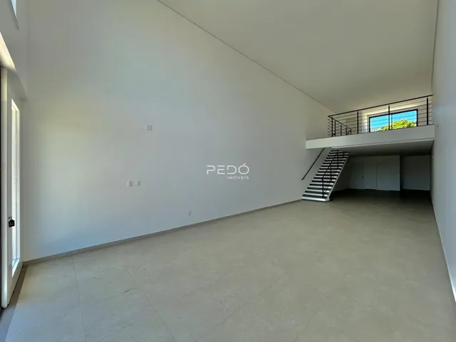 Espaço interno amplo com paredes brancas e piso claro.