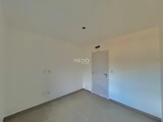 Vista interna de um cômodo com paredes brancas e piso claro.