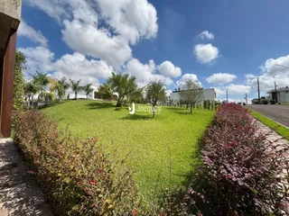 Vista externa de um jardim gramado com vegetação densa em Lajeado.