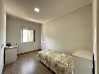 Foto de um quarto com piso de madeira e uma cama em um imóvel no Brasil.