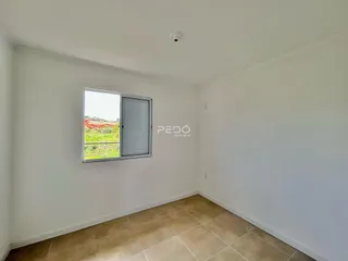Ambiente interno com piso de cerâmica e vista para a paisagem rural.