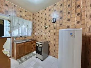 Interior de uma cozinha com revestimento de parede em padrão de ladrilhos.