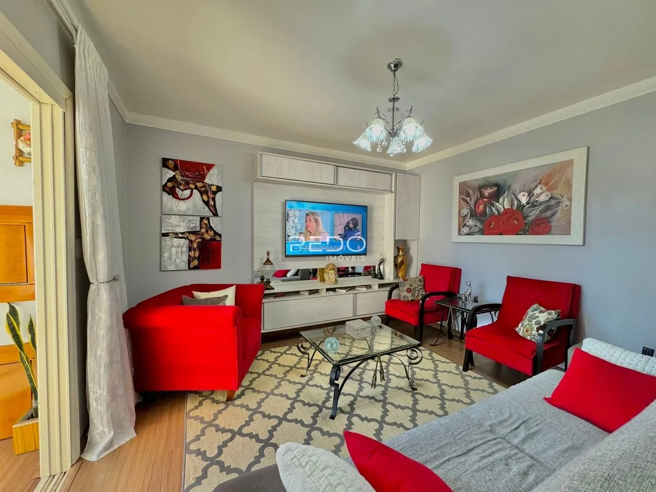 Sala de estar com sofás vermelhos e decoração moderna.