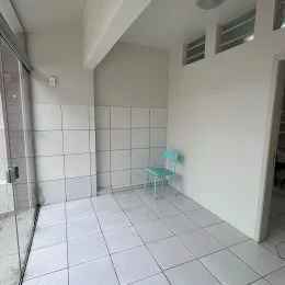 Foto de um ambiente interno com piso e paredes brancas.