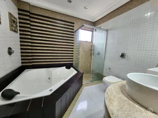 Banheiro com banheira e box de vidro em um imóvel.