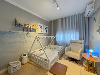 Quarto com cama de madeira e decoração de parede azul e branca.