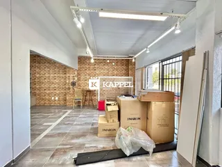 Hall de entrada com paredes de tijolo aparente e piso de concreto.