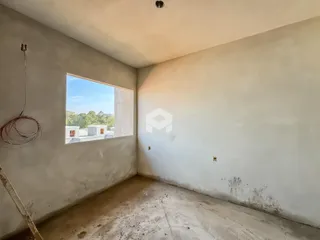 Vista interna de um cômodo com paredes em estado de acabamento.