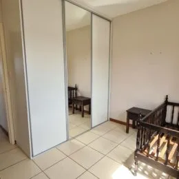 Vista interna de um corredor com paredes brancas e painéis.