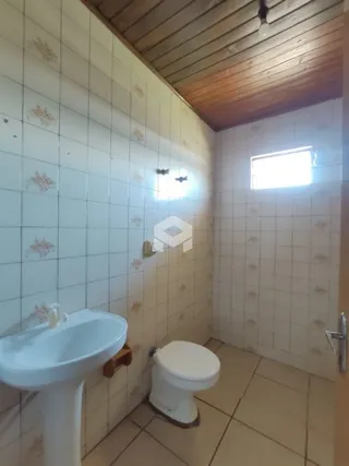 Foto de um banheiro com azulejos brancos e vaso sanitário.