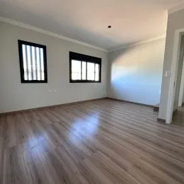 Foto de um ambiente interno com piso de madeira clara.