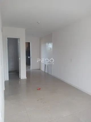Corredor interno de uma residência com piso de cerâmica clara.