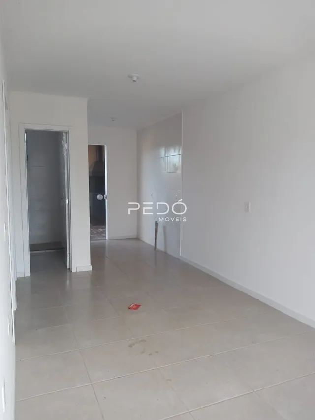Corredor interno de uma residência com piso de cerâmica clara.