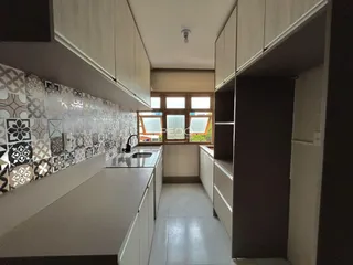 Vista da cozinha moderna com armários brancos e revestimento de azulejos na Lajeado.