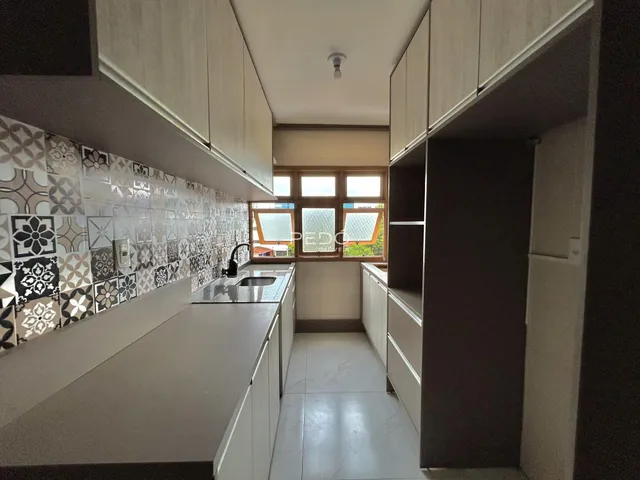 Vista da cozinha moderna com armários brancos e revestimento de azulejos na Lajeado.