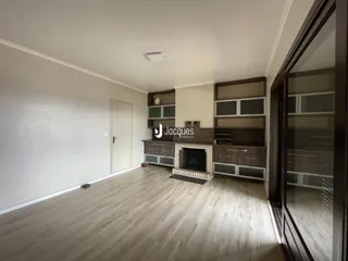 Sala de estar com piso de madeira e painéis de parede em um imóvel no Brasil.