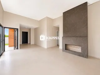 Ambiente interno amplo com paredes brancas e uma coluna decorativa escura.