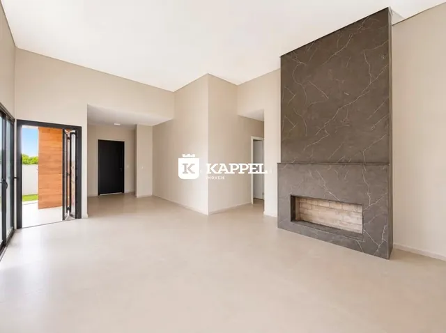Ambiente interno amplo com paredes brancas e uma coluna decorativa escura.
