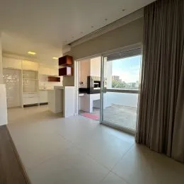 Sala de estar iluminada com porta de vidro que dá acesso a uma área externa.