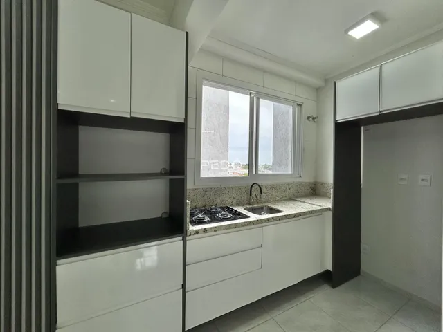 Foto de uma cozinha moderna com armários brancos e bancada de granito.