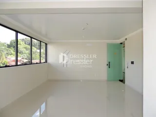Sala ampla com grandes janelas de vidro.