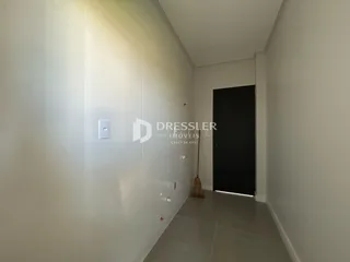Corredor interno de uma residência com paredes brancas.
