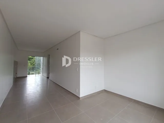 Corredor com piso de cerâmica e paredes brancas.