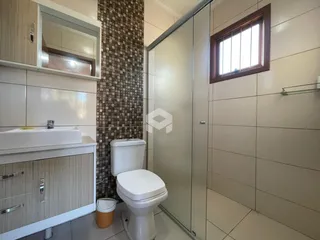 Foto de um banheiro com azulejos e bancada branca.