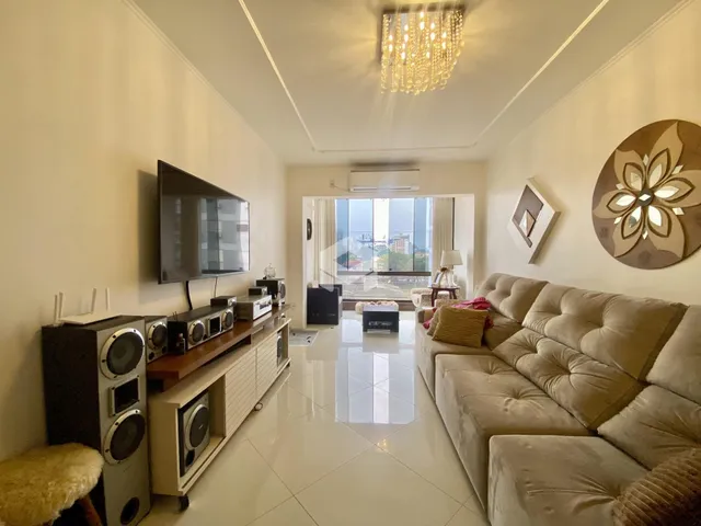 Sala de estar moderna com sofá e televisão em um apartamento.