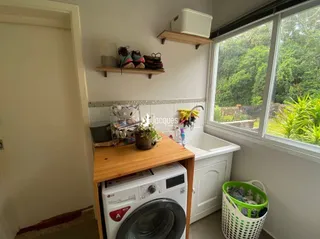 Foto de um ambiente interno com máquina de lavar roupa e janela.