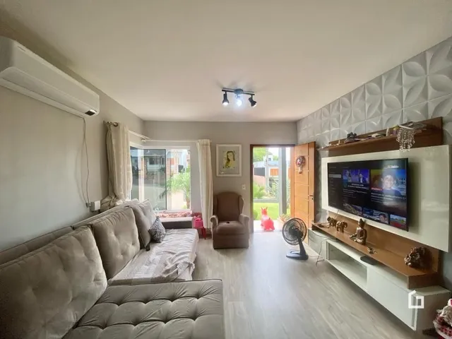 Sala de estar com sofá e televisão em um imóvel no Brasil.