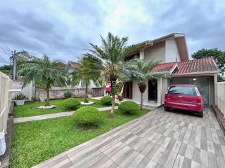 Fachada de uma casa em Lajeado, Brasil, com jardim e área pavimentada.