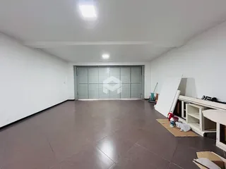 Imagem de um cômodo interno vazio com piso de cerâmica e portas de vidro.