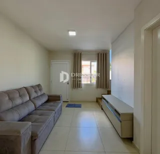 Sala de estar com sofá e piso de cerâmica clara.