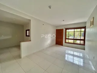 Hall de entrada com piso de cerâmica e paredes brancas.