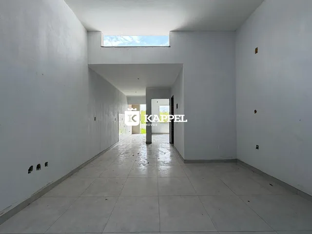 Corredor longo com paredes brancas e piso de cerâmica.
