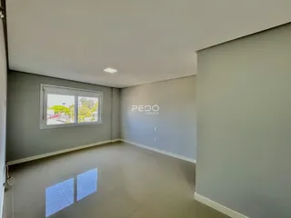 Esta é uma vista interna de uma sala com paredes cinzas e piso claro.