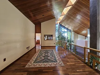 Sala de estar com piso de madeira e teto de madeira.