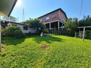 Gramado verde com árvores ao redor da residência.