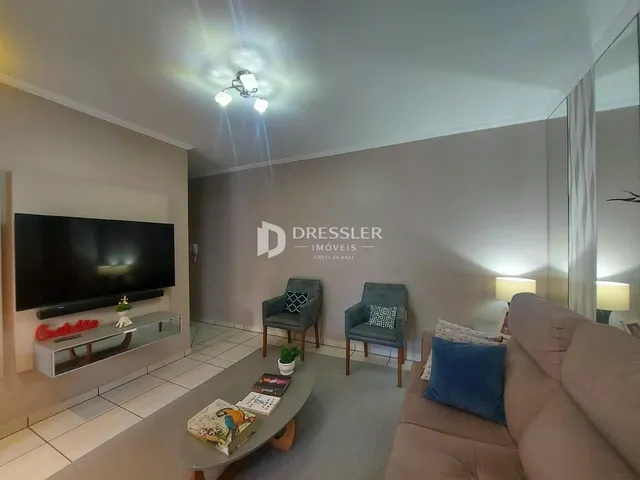 Sala de estar com sofá e televisão em um imóvel no Brasil.